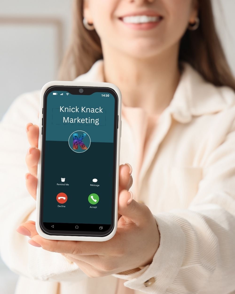 Sarah Fisher holding a phone displaying a Contact Us message for Knick Knack Marketing